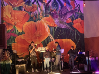 A large mural with hummingbird and orange poppies while jazz musicians play